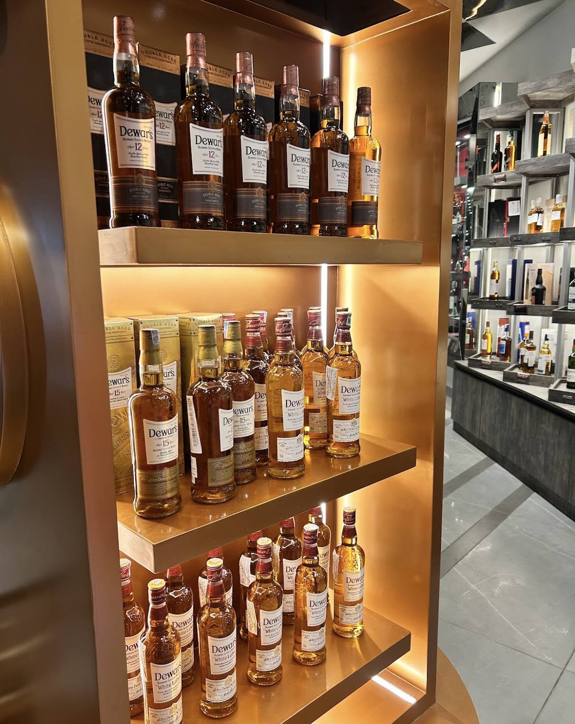 Air-conditioned retail theka in Noida featuring premium whisky, wine, and beer brands