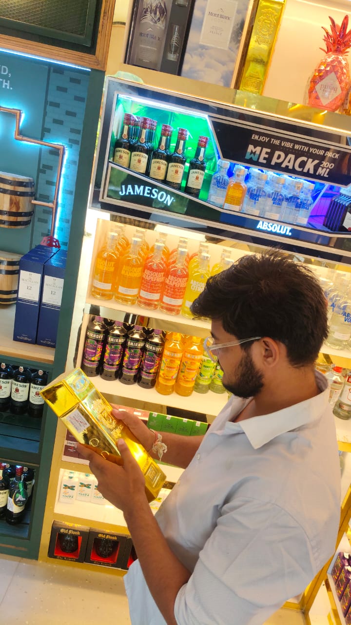 Customers exploring premium whisky and wine collection at liquor store