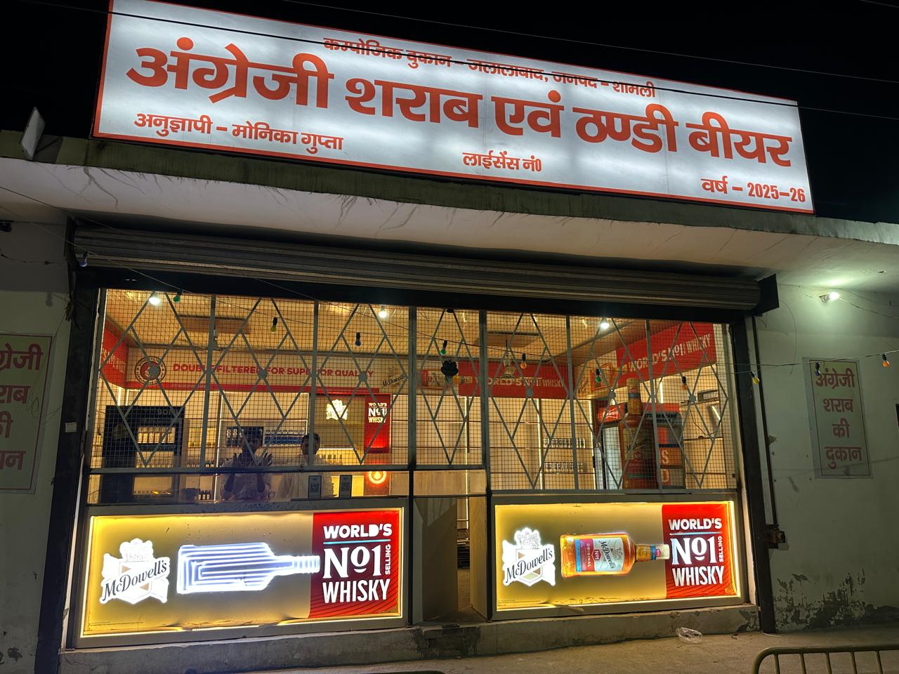 Whisky and rum bottles lined up at local liquor shop counter